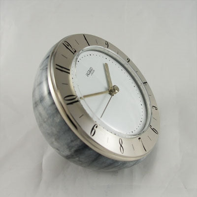 "Conte-2" Jaccard Solid Grey Marble base finished to a high polish. Solid Silvered Brass Time Ring and Arabic numerals. Quartz battery movement. Size:80mm high x 75mm deep.